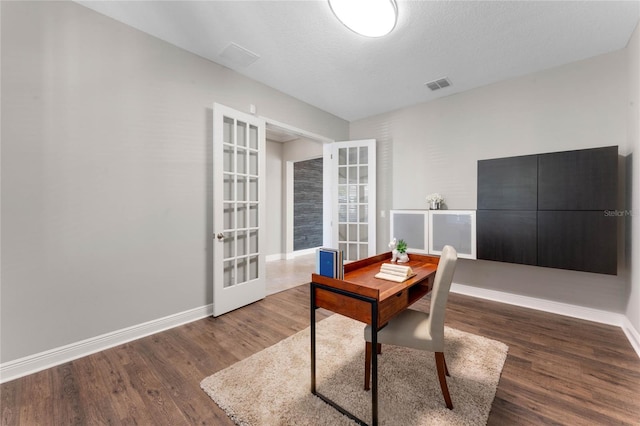 office space featuring french doors, baseboards, visible vents, and wood finished floors