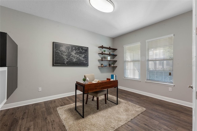 home office featuring a textured ceiling, baseboards, and dark wood-style flooring