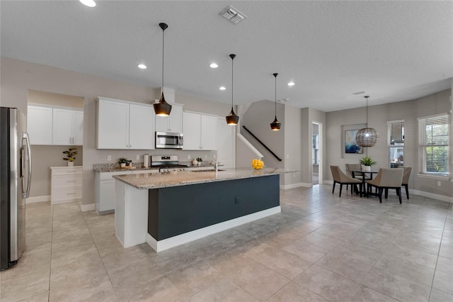 kitchen featuring white cabinetry, a kitchen island with sink, appliances with stainless steel finishes, and a sink