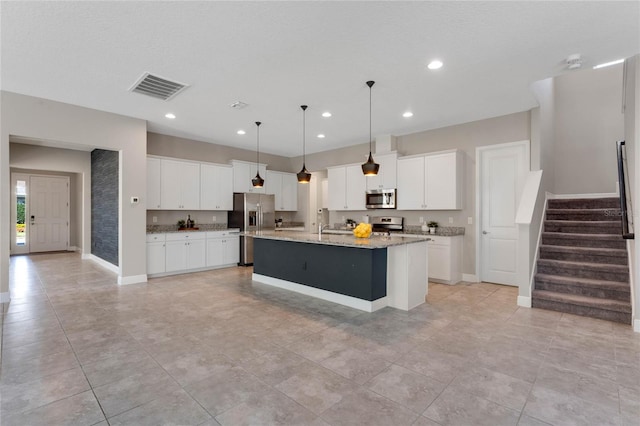 kitchen with recessed lighting, visible vents, a center island with sink, and stainless steel appliances