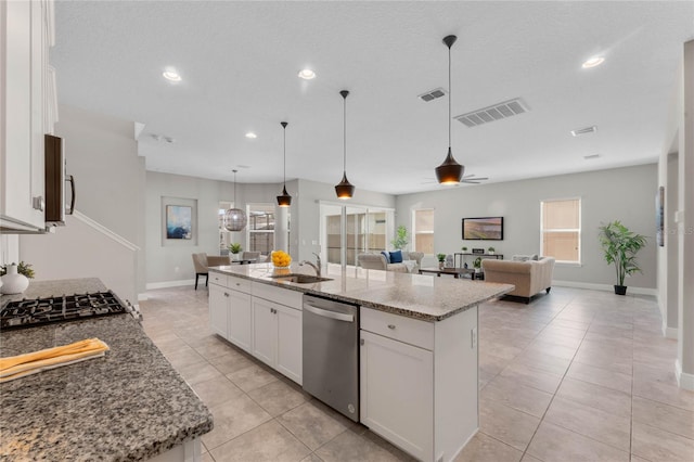 kitchen with white cabinets, light stone counters, visible vents, and appliances with stainless steel finishes