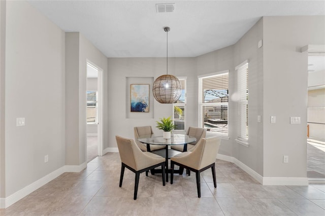 dining space with light tile patterned flooring, visible vents, and baseboards