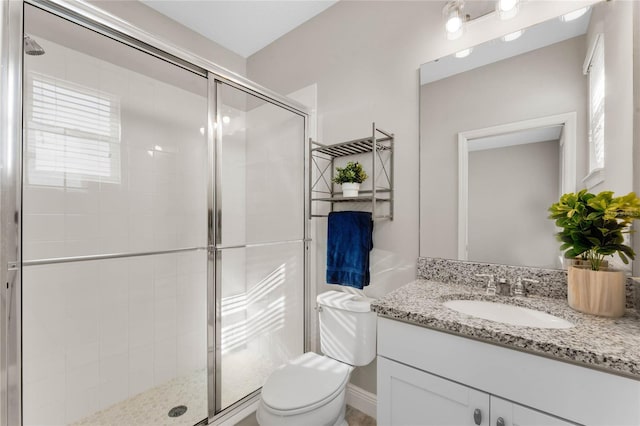 bathroom featuring a stall shower, toilet, and vanity