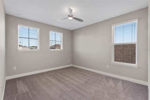 carpeted spare room with baseboards and a ceiling fan