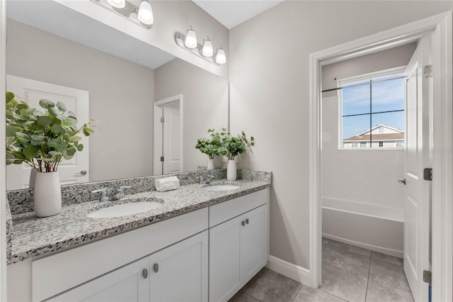 full bath with a sink, baseboards, double vanity, and tile patterned flooring