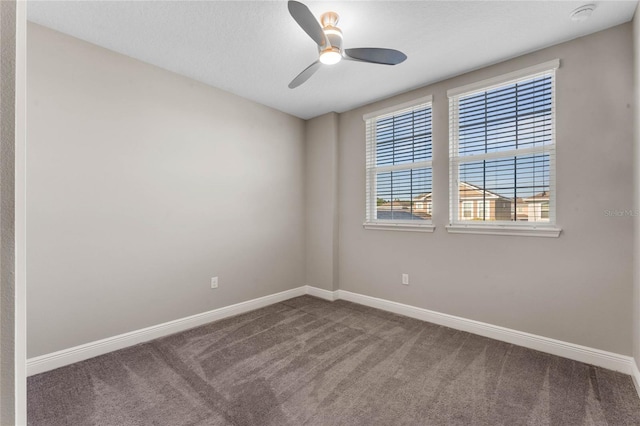 carpeted empty room featuring a ceiling fan and baseboards