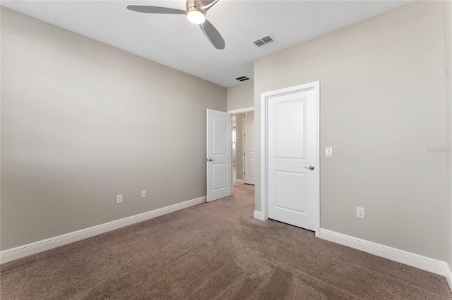 spare room with visible vents, baseboards, carpet, and a ceiling fan