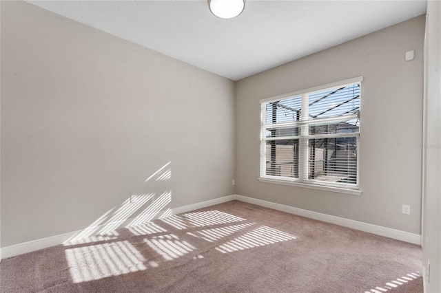 carpeted spare room with baseboards