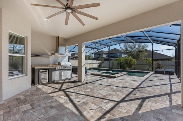 view of patio featuring a pool with connected hot tub, beverage cooler, glass enclosure, an outdoor kitchen, and a ceiling fan