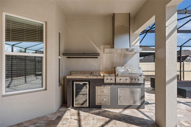 view of patio / terrace with beverage cooler, a sink, an outdoor kitchen, a grill, and a lanai