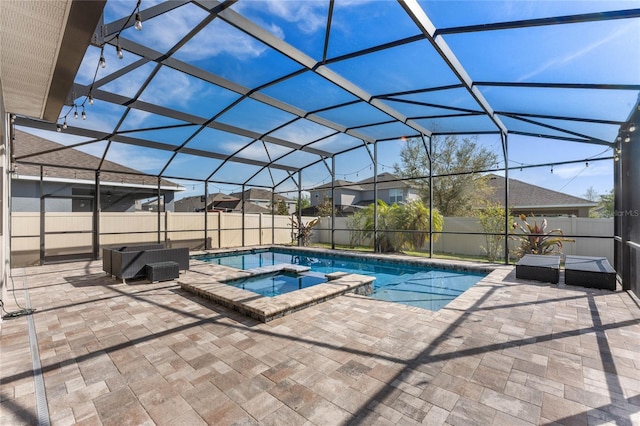 view of swimming pool with a lanai, a patio area, a fenced backyard, and a pool with connected hot tub