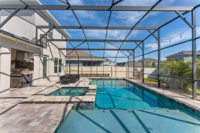 view of swimming pool featuring glass enclosure, a pool with connected hot tub, and a patio area