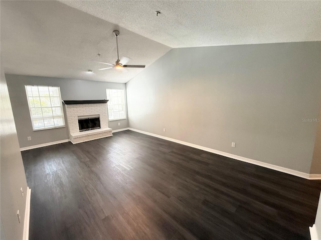 1010 Loch Vail Unit 1125, Apopka, FL 32712 - unfurnished living room featuring ceiling fan, dark wood-type flooring, vaulted ceiling, a textured ceiling, and baseboards