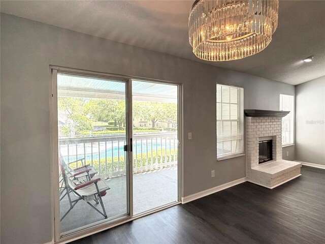 1010 Loch Vail Unit 1125, Apopka, FL 32712 - unfurnished living room featuring dark wood finished floors, healthy amount of natural light, baseboards, and a brick fireplace