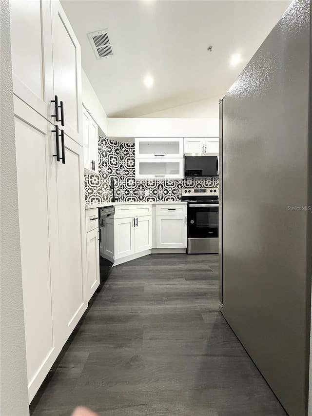 1010 Loch Vail Unit 1125, Apopka, FL 32712 - kitchen featuring appliances with stainless steel finishes, decorative backsplash, white cabinets, dark wood-type flooring, and lofted ceiling