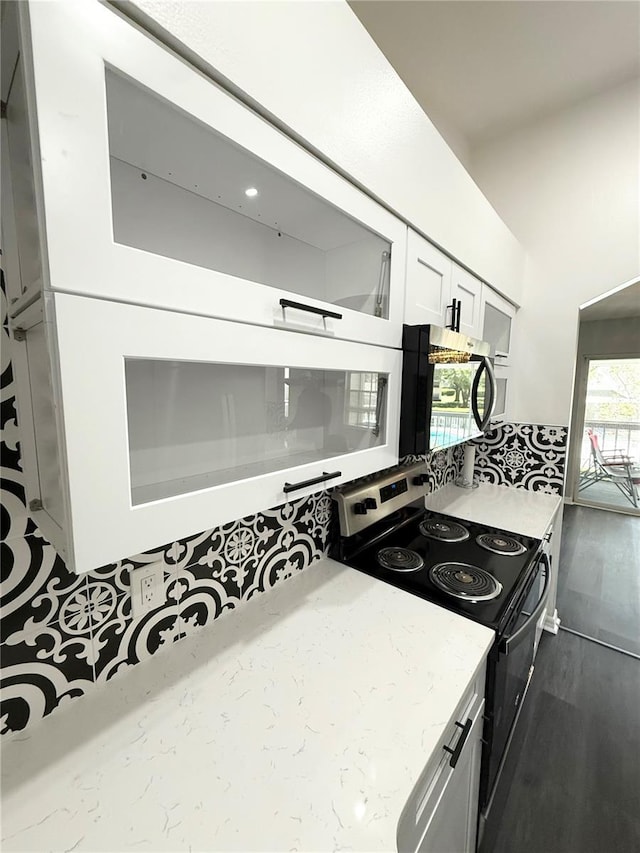 1010 Loch Vail Unit 1125, Apopka, FL 32712 - kitchen with electric range, stainless steel microwave, light stone countertops, white cabinetry, and dark wood-style floors