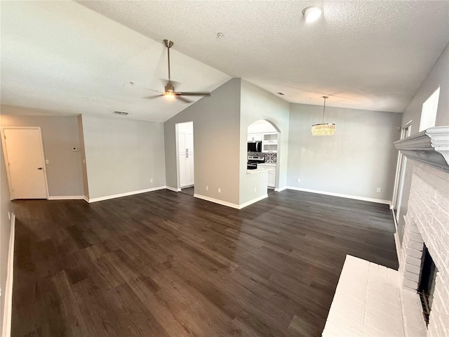 1010 Loch Vail Unit 1125, Apopka, FL 32712 - unfurnished living room featuring a brick fireplace, a ceiling fan, baseboards, dark wood-style floors, and lofted ceiling