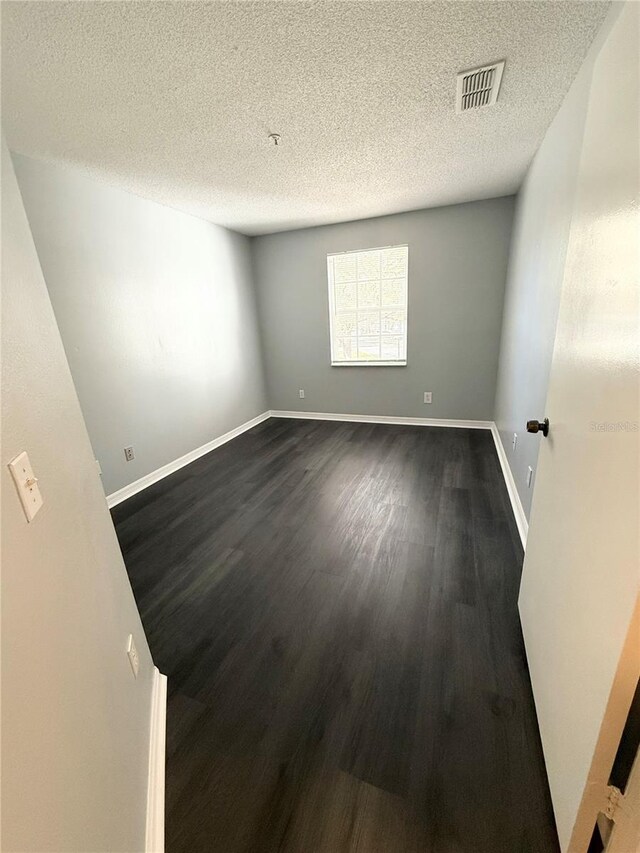 1010 Loch Vail Unit 1125, Apopka, FL 32712 - spare room with dark wood-style flooring, a textured ceiling, and baseboards