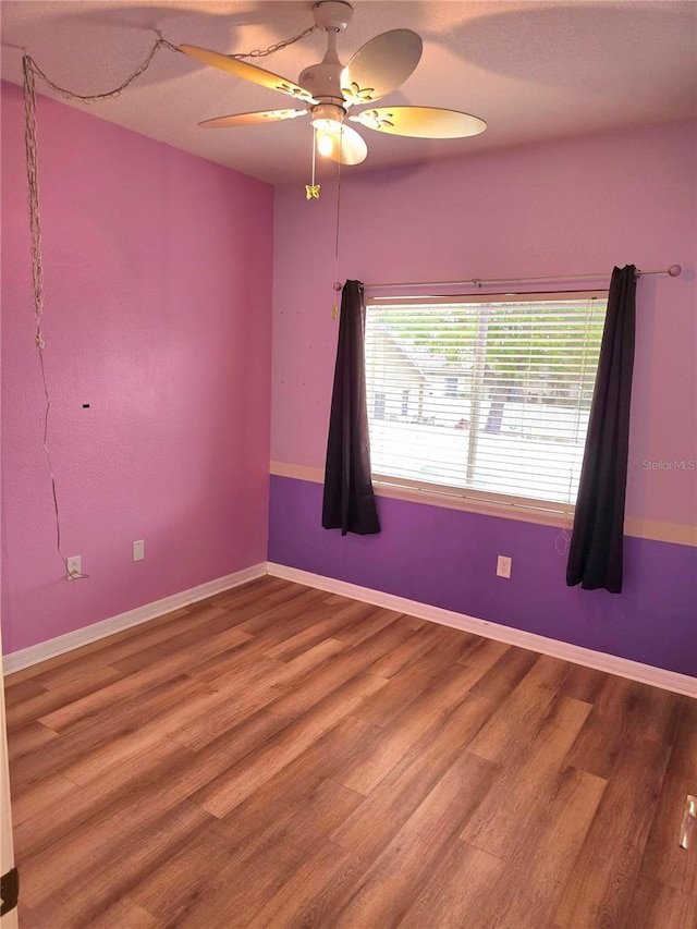 25012 Chipshot Ct, Sorrento, FL 32776 - empty room featuring wood finished floors, ceiling fan, and baseboards
