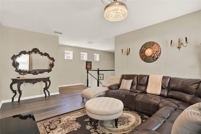 living room featuring visible vents, baseboards, an inviting chandelier, and wood finished floors