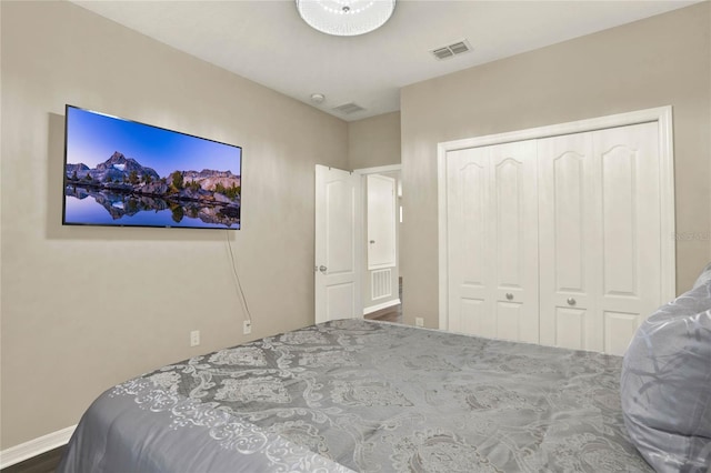 bedroom with baseboards, visible vents, and a closet