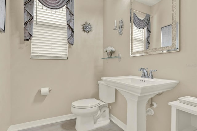bathroom featuring toilet and baseboards