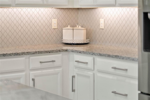 room details with white cabinetry and light stone countertops