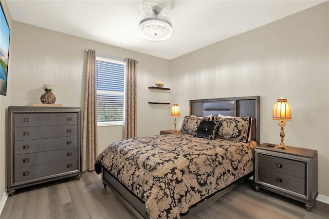 bedroom with baseboards and wood finished floors