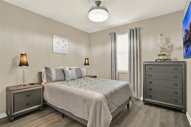 bedroom with baseboards and wood finished floors