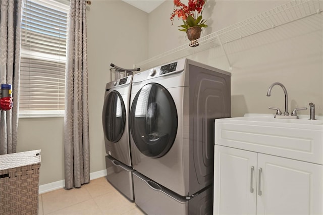 laundry room featuring light tile patterned floors, baseboards, and washer and clothes dryer