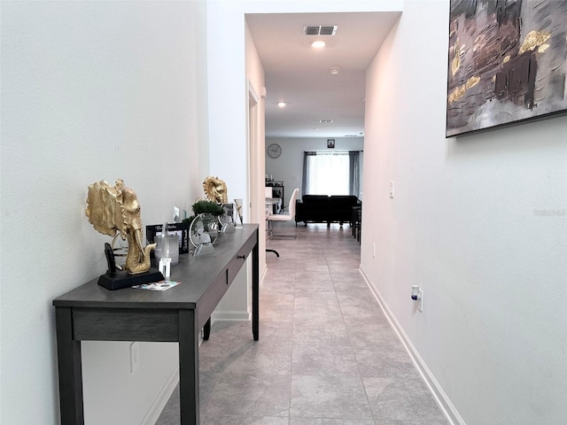 corridor with tile patterned floors, baseboards, and visible vents