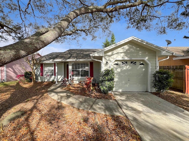 ranch-style home with an attached garage, fence, and driveway