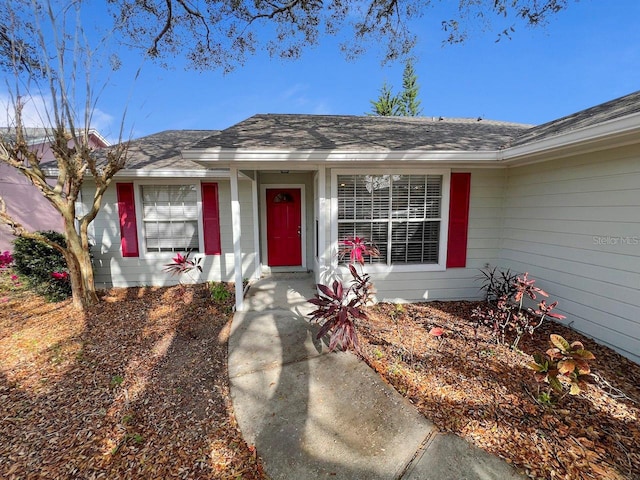 entrance to property with roof with shingles