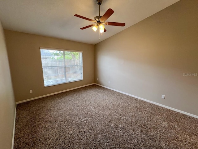 spare room featuring vaulted ceiling, baseboards, carpet floors, and ceiling fan