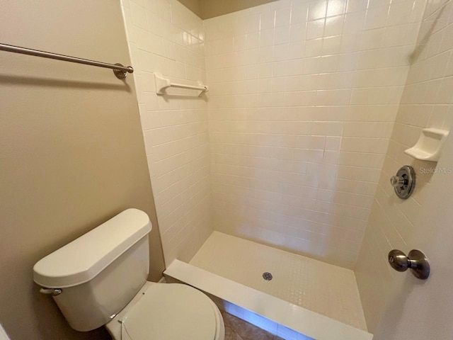 full bath with toilet and a tile shower