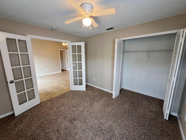 unfurnished bedroom with visible vents, carpet floors, french doors, a closet, and a textured ceiling