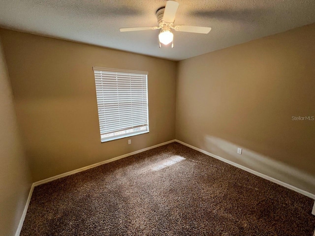 empty room with a textured ceiling, carpet, baseboards, and ceiling fan