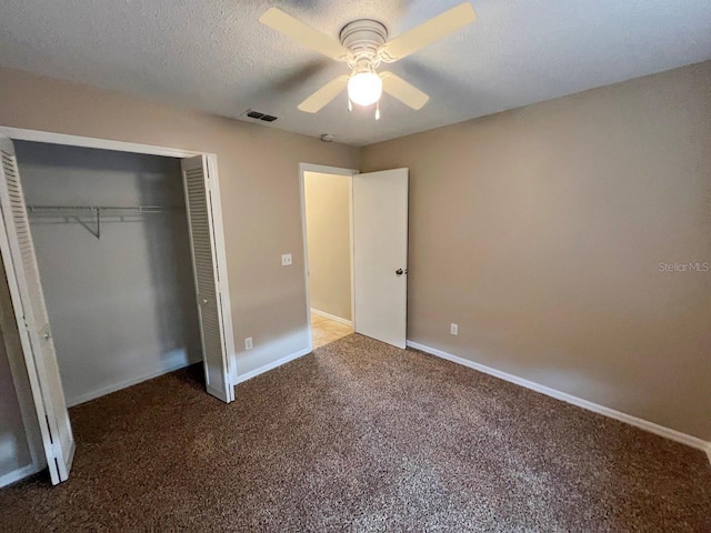 unfurnished bedroom featuring visible vents, a textured ceiling, a closet, carpet floors, and baseboards