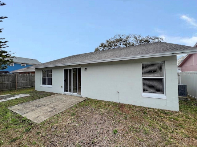 back of house featuring cooling unit, a fenced backyard, a lawn, and a shingled roof