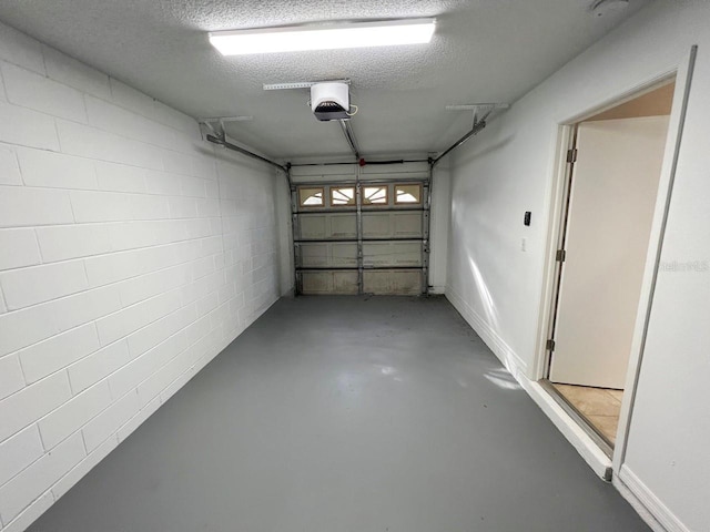 garage with concrete block wall and a garage door opener