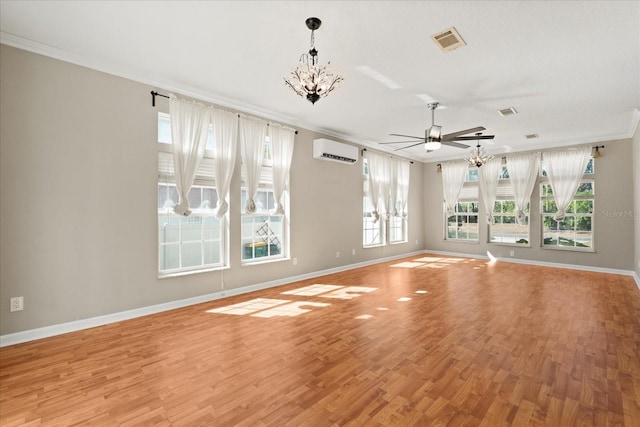unfurnished living room with light wood-style floors, ceiling fan with notable chandelier, ornamental molding, and visible vents