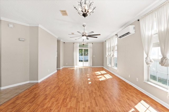 empty room with light wood finished floors, visible vents, a wall unit AC, and ornamental molding