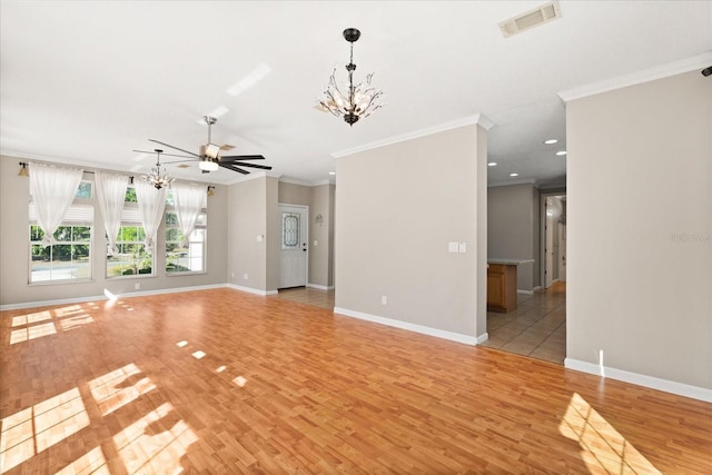 unfurnished living room with baseboards, an inviting chandelier, ornamental molding, light wood-style floors, and visible vents