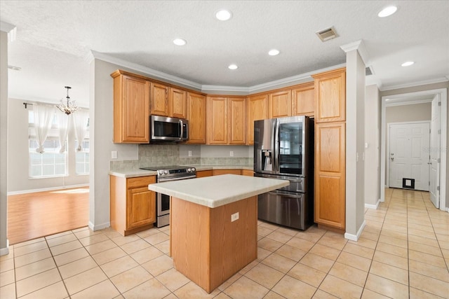 kitchen with light countertops, crown molding, light tile patterned flooring, visible vents, and appliances with stainless steel finishes