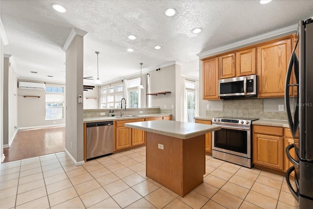 kitchen featuring a wall mounted AC, appliances with stainless steel finishes, light tile patterned floors, and a sink