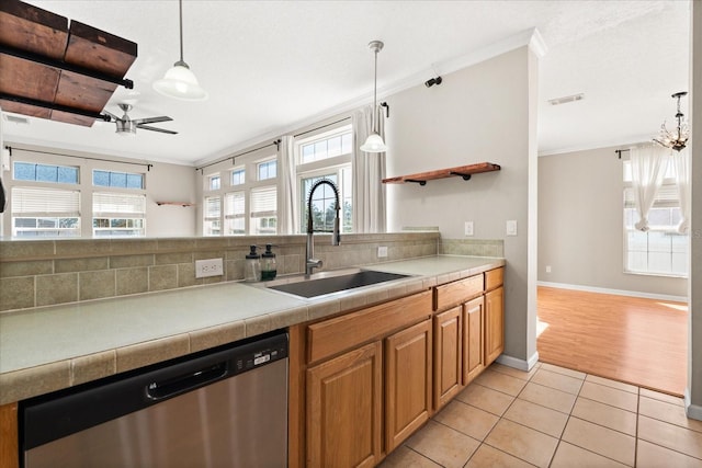 kitchen featuring dishwasher, a sink, and crown molding