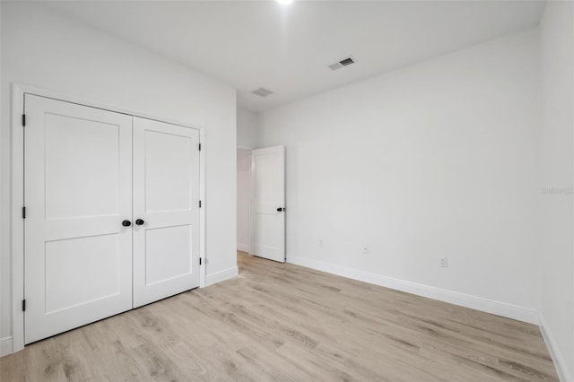 7564 N Gims Way, Citrus Springs, FL 34433 - unfurnished bedroom with light wood finished floors, baseboards, and a closet