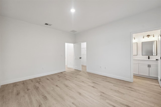 7564 N Gims Way, Citrus Springs, FL 34433 - unfurnished bedroom with light wood finished floors, baseboards, connected bathroom, and a spacious closet