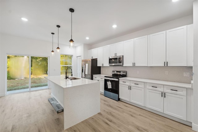 7564 N Gims Way, Citrus Springs, FL 34433 - kitchen featuring appliances with stainless steel finishes, a sink, light wood-style floors, white cabinets, and decorative light fixtures