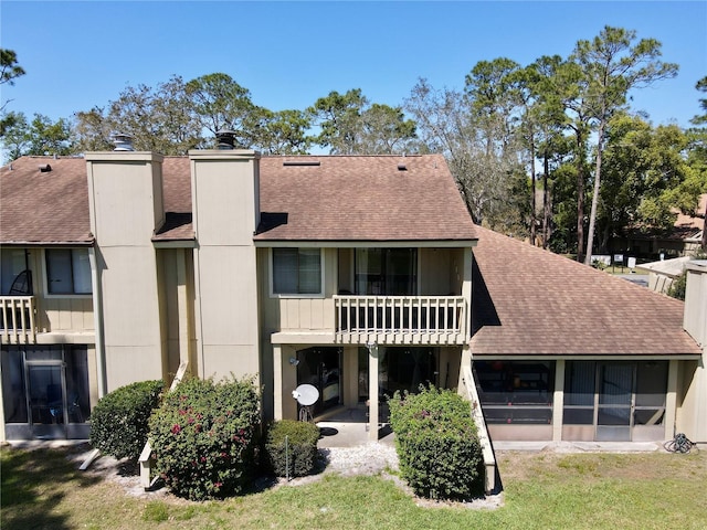 1886 Saint Andrews Pl Unit 1886, Longwood, FL 32779 - back of property featuring a balcony, a shingled roof, and a chimney